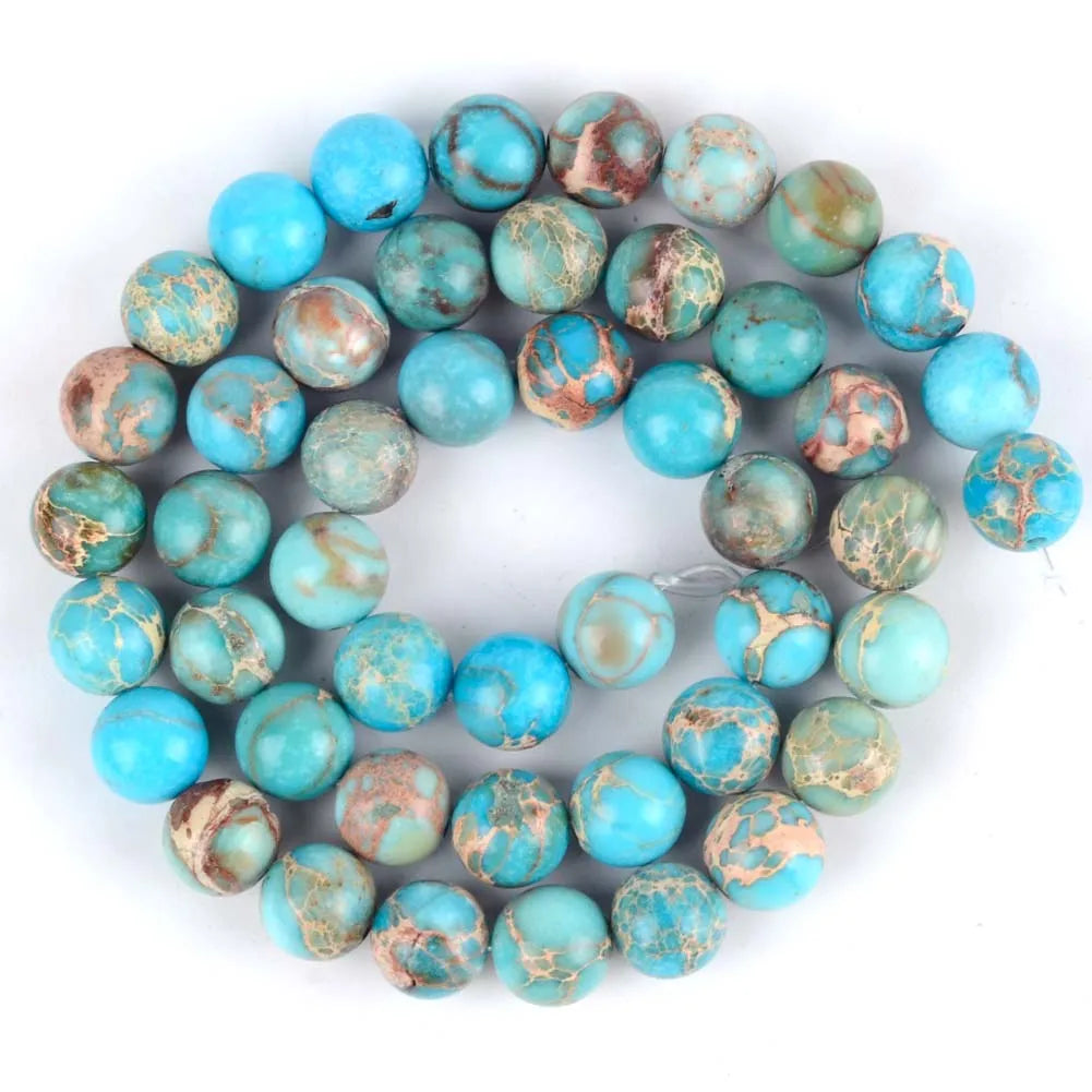 A circular arrangement of natural sea sediment jasper and turquoise beads for jewelry making