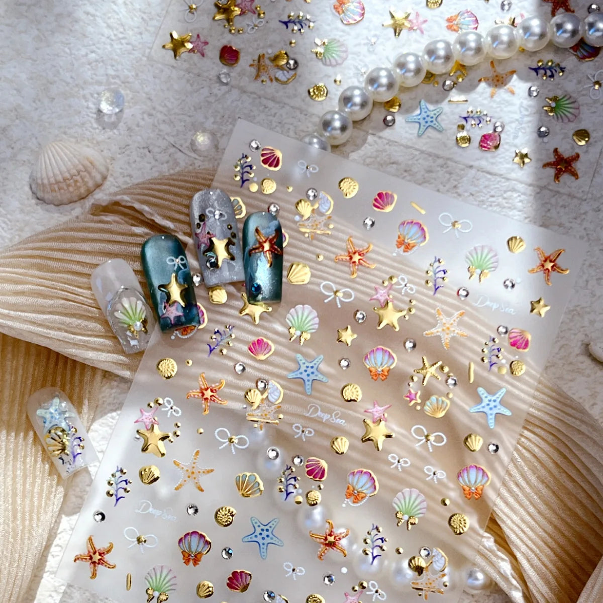 Clear stickers featuring 3D ocean-themed nail art with gold shells and starfish