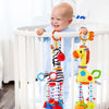 Lächelndes Baby hält eine Giraffen-Zebra-Handglocke-Plüschpuppe in einem weißen Kinderbett.