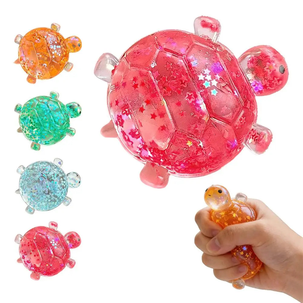 A hand holds a bright pink glittery squishy star turtle stress relief fidget ball with various colored versions nearby.