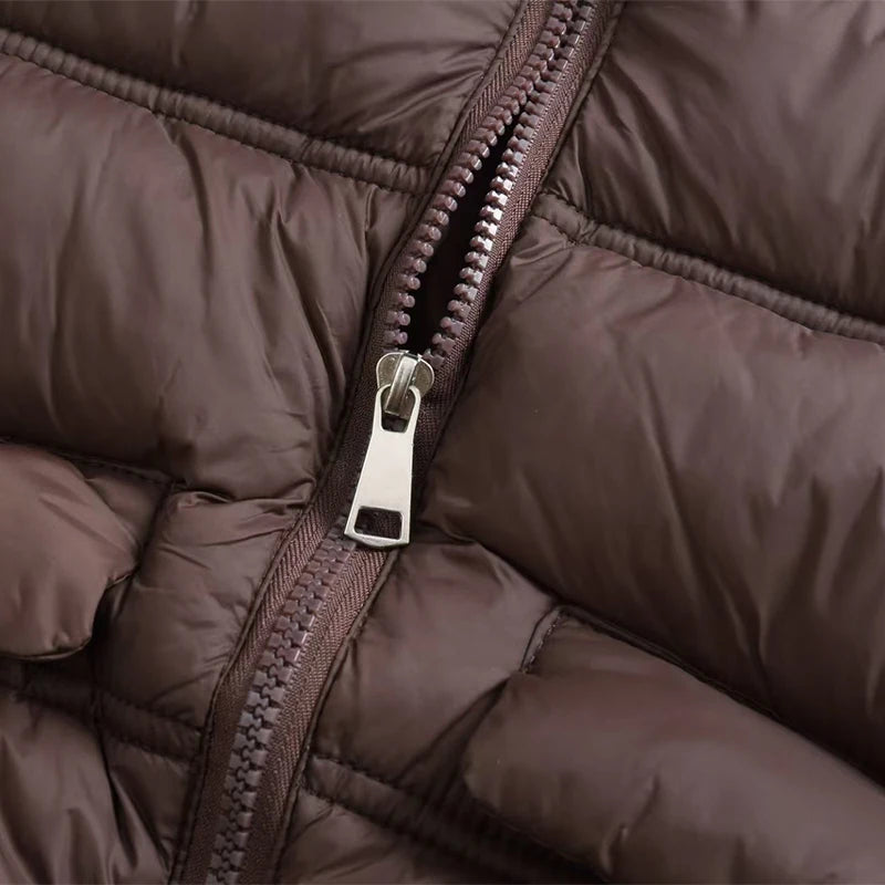 Close-up of a brown padded down vest showing the zipper and hardware.