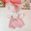 A pink plush teddy bear with a white face and a matching pink knitted dress.