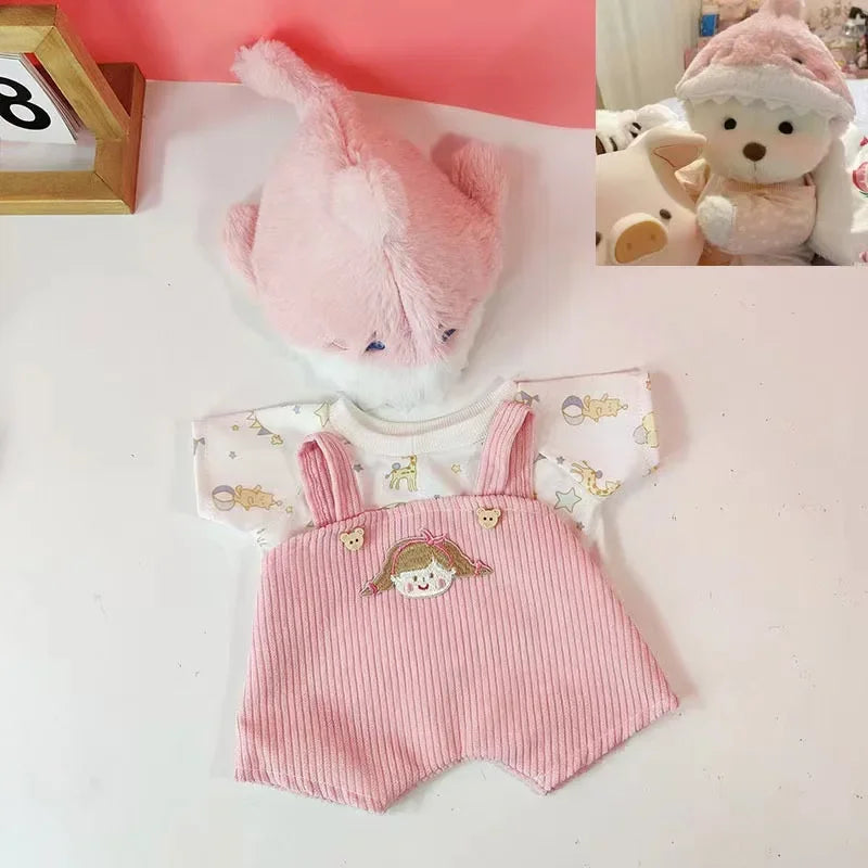 A pink plush teddy bear with a white face and a matching pink knitted dress.