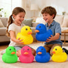A collection of colorful squeeze duck stress relief toys, including yellow, blue, and pink ducks, are displayed on a carpet.