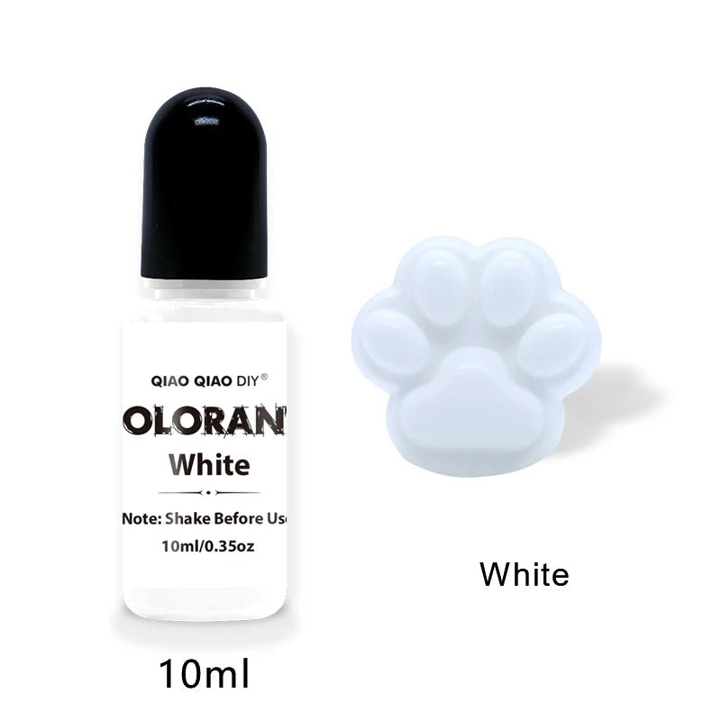 A white glass dropper bottle labeled Oloran White with a black cap and a white paw print silicone mold nearby.
