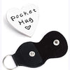 A black silicone pocket hug token with a silver keychain attached.