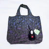 A black fabric bag featuring a pattern of blue and purple geometric shapes, with a small black hippo plush toy inside.