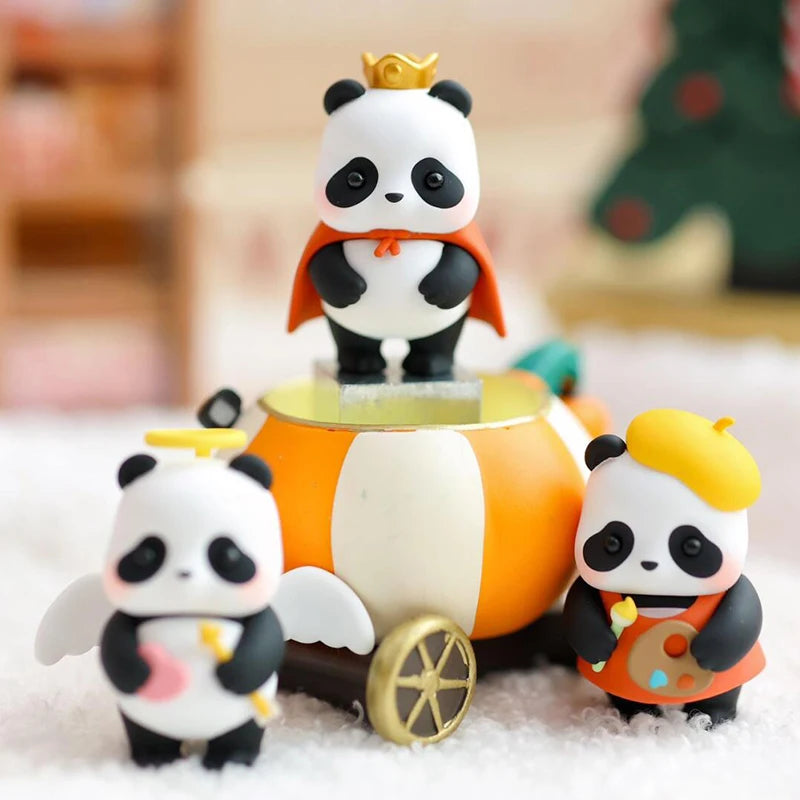 A blind box collectible figure of a panda wearing an orange cape and a gold crown, sitting on white snow.