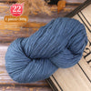 A skein of blue-gray yarn is shown on a wooden surface, ready for knitting or crafting.
