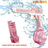 A pink and white electric water battle gun is shown firing a stream of water, with a detachable pink bottle nearby.