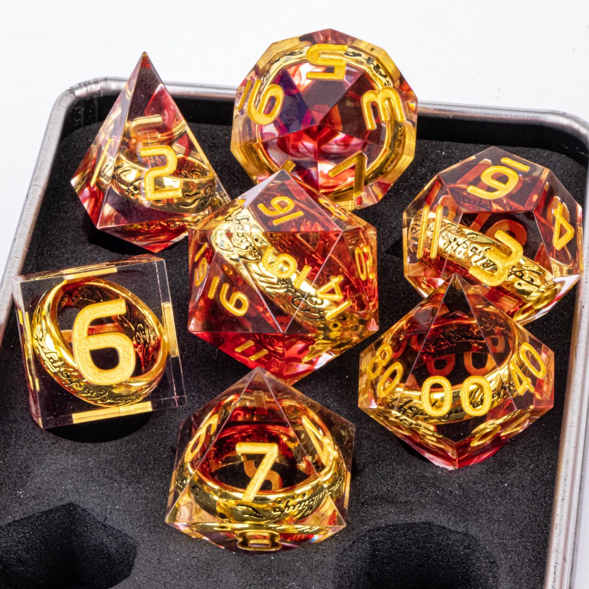A set of resin dice inspired by Lord of the Rings featuring golden elven numbers in various shapes and colors.