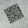 A square decal featuring a black leopard print pattern on a gray surface.