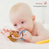 A baby is using a food-grade silicone planet teether, which is yellow and blue, on their gums.