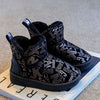 A pair of black girls' winter fur-lined snow boots with a non-slip sole resting on a light surface.