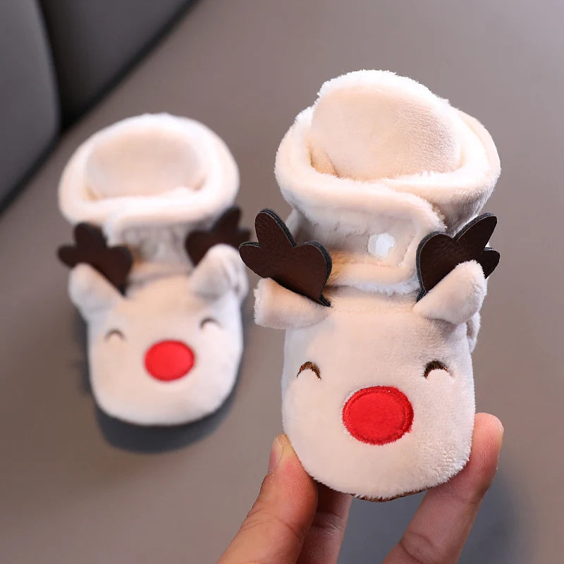 A pair of adorable animal-themed baby first walker shoes resembling reindeer heads made of soft white fleece.