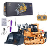 An orange remote control excavator toy with a black bucket and yellow details, shown with its packaging and accessories.