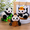 A set of mini panda building blocks featuring black and white pandas with orange accents, displayed in a wooden frame.