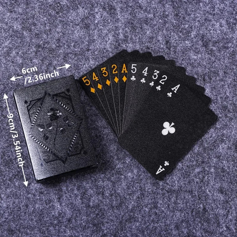 A black playing card deck with gold numbering and aces is shown against a gray textured background.