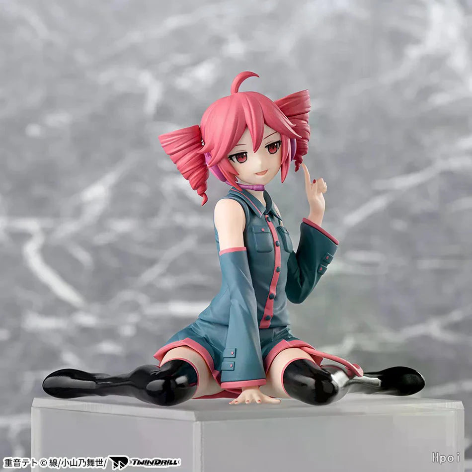 A PVC figure of Hatsune Miku with pink hair and a teal outfit sitting on a white base.