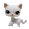 A white Littlest Pet Shop style standing dog figure with large blue eyes.