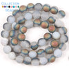 A collection of iridescent beads featuring shades of blue, green, and purple resembling natural sea sediment and turquoise fo