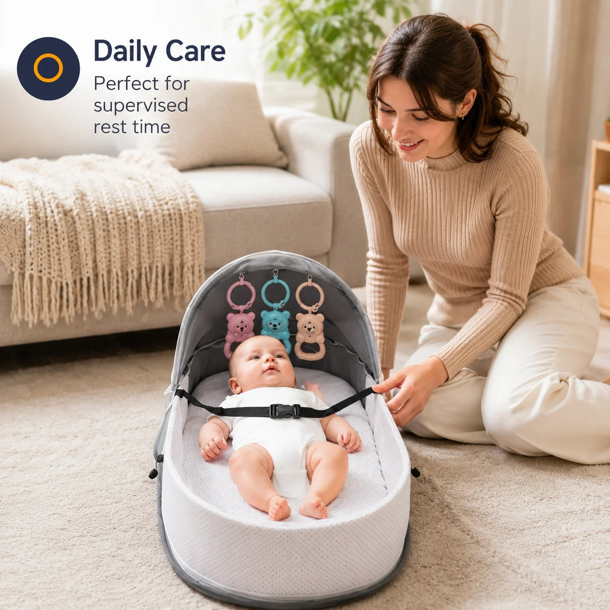A woman is sitting on the floor with a portable foldable baby bed for supervised rest time placed in front of her.