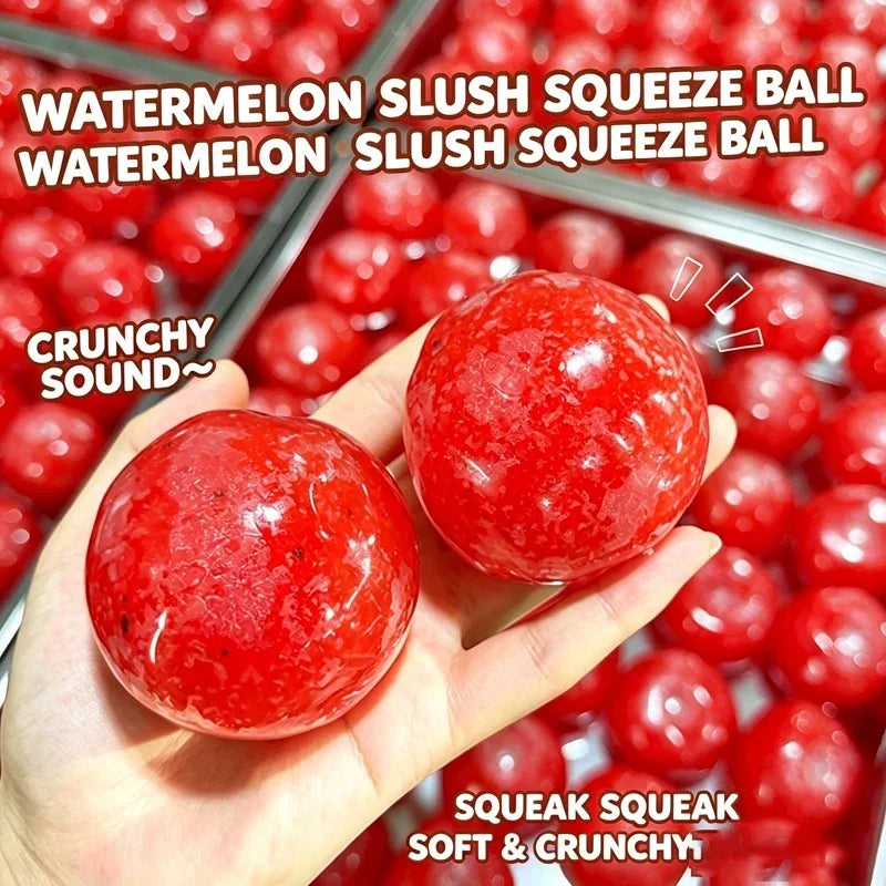 A hand holds a bright red watermelon slush squeeze ball against a background of many similar balls.