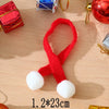 A red knitted Christmas hat and scarf set for dolls displayed on a wooden surface.