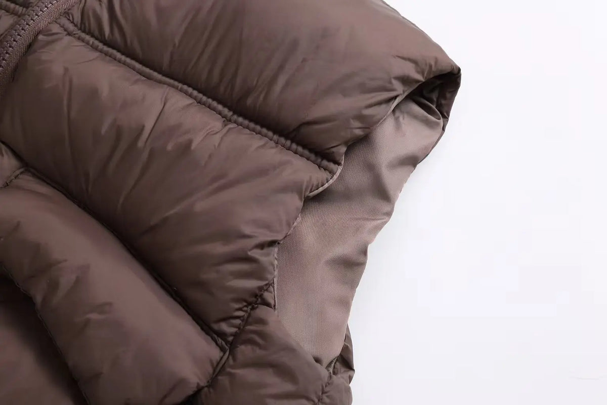 Close-up view of a dark brown padded down vest fabric.