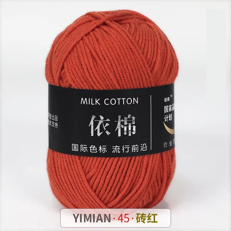 A skein of orange milk cotton yarn labeled YIMIAN 45 and 砖红 for knitting or crochet.