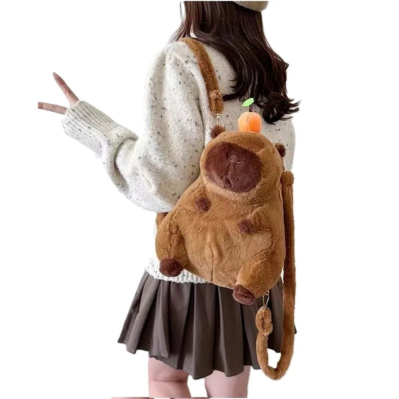 A woman is holding a brown capybara plush toy with a skirt, featuring a mama and four babies.