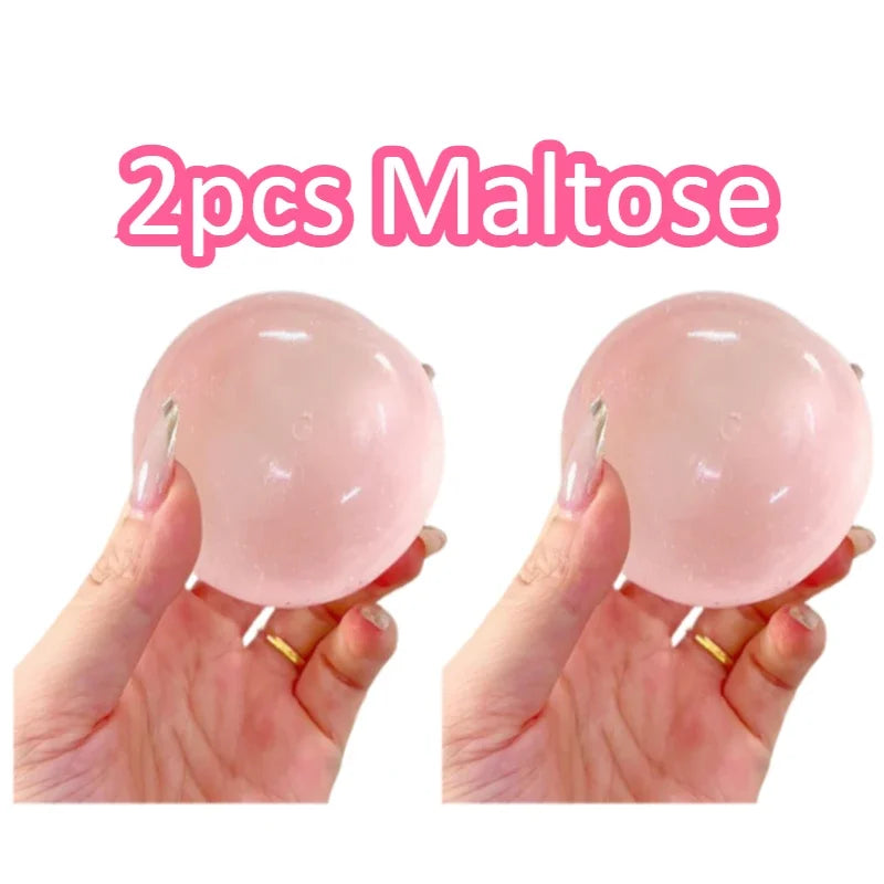 Two pink maltose squishy toys being held in hands
