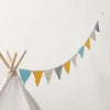 A banner of triangular fabric pennants in light blue, yellow, and gray strung across a white wall.