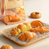 A set of realistic pretend play food items including bread rolls and pastries displayed on a tray.