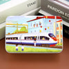 A rectangular jigsaw puzzle featuring a train and houses with colorful figures on a wooden background.
