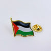 A gold lapel pin shaped like the flag of Palestine featuring black, white, and green stripes.