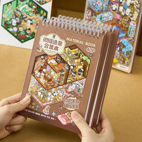 A brown spiral notebook shows illustrations of miniature scenes and stickers for a 3D landscape set.