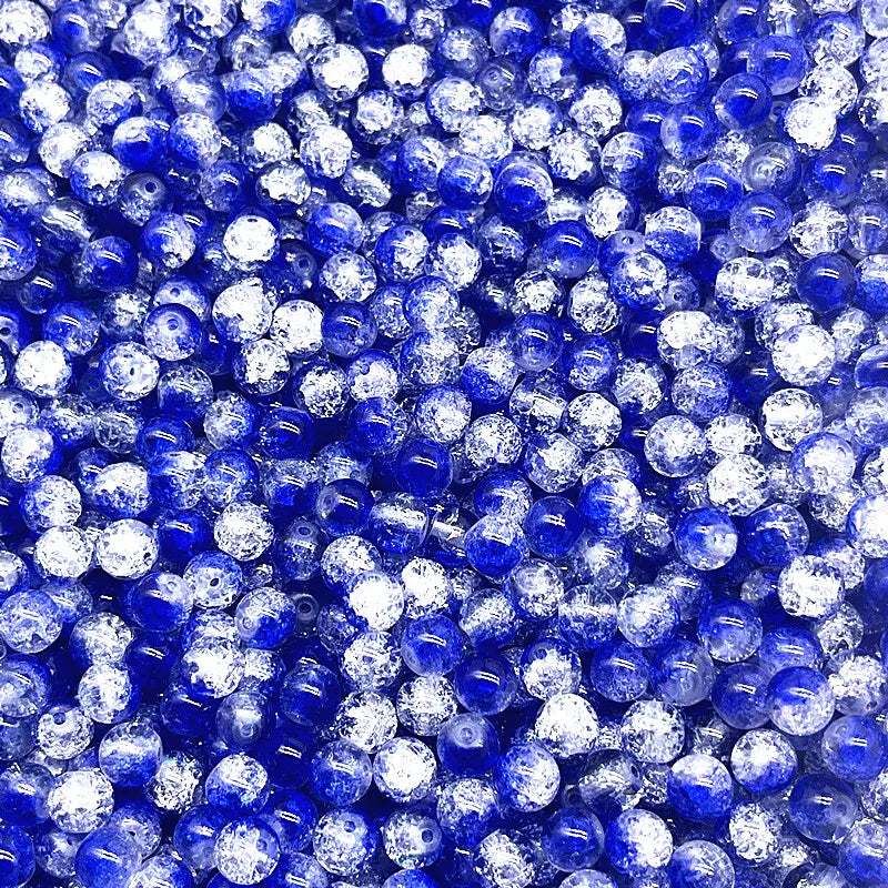 A close-up view of round blue and clear crackle glass beads for jewelry making.