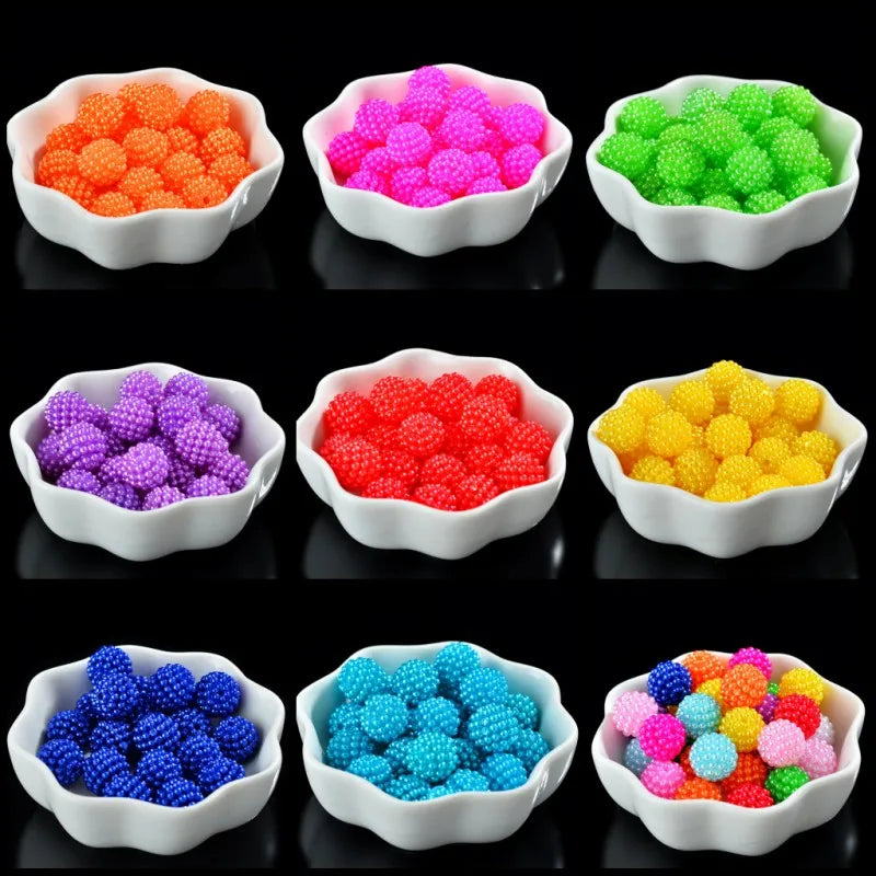 A collection of brightly colored acrylic pearl beads in various shades including orange, pink, purple, green, yellow, and blu