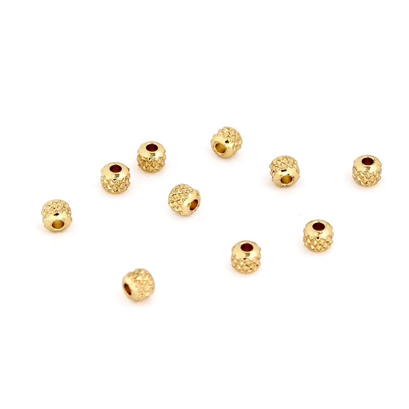 A collection of small gold stainless steel round spacer beads for jewelry making.