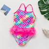 A vibrant, iridescent mermaid unicorn one-piece swimsuit featuring a scale pattern in pink, blue, and green.