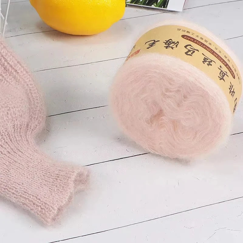 Pink mohair blended yarn skein with a yellow lemon in the background