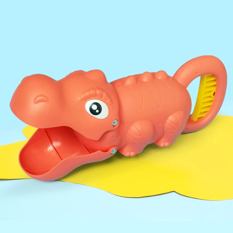 An orange plastic dinosaur toy with a yellow claw and digging tools lying on a light blue surface.