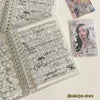 A close-up of a clear plastic sticker book filled with intricate black and white line art and decorative elements for journal