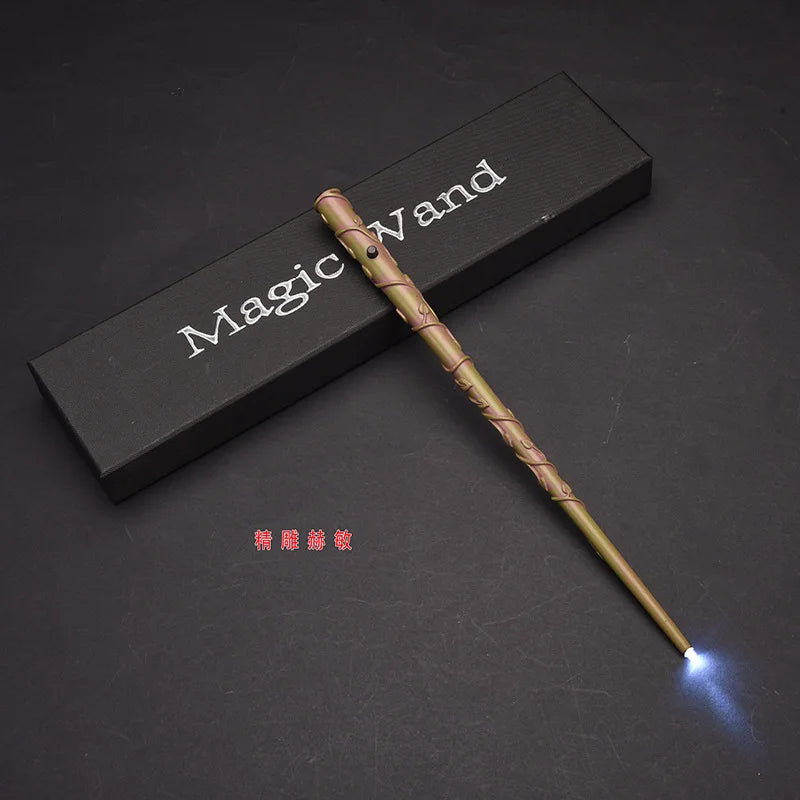 A golden magic wand with an LED light tip rests on a dark surface next to a wooden box labeled Magic Wand.