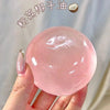 A hand holds a clear pink squishy stress relief ball made from coconut oil.