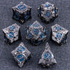 A set of ten metallic dice featuring blue accents and a silver finish arranged on a dark gray surface.