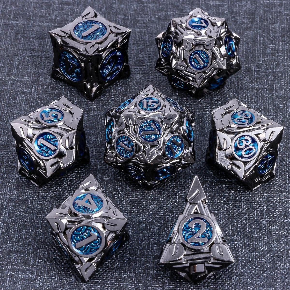A set of ten metallic dice featuring blue accents and a silver finish arranged on a dark gray surface.