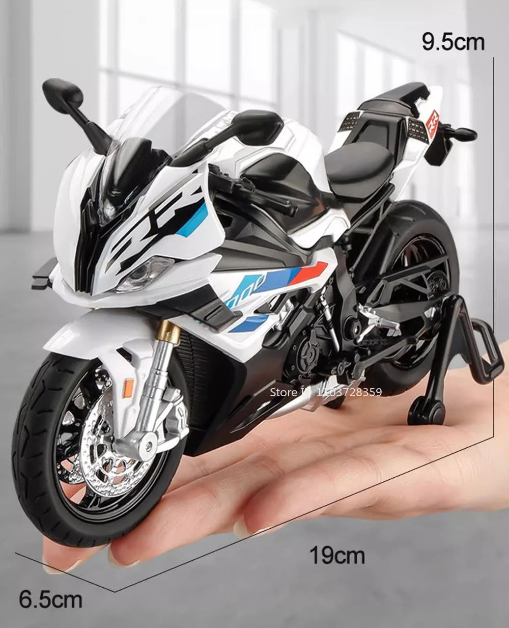 A white and black 1:12 scale die-cast model motorcycle with front steering is shown resting on a hand.