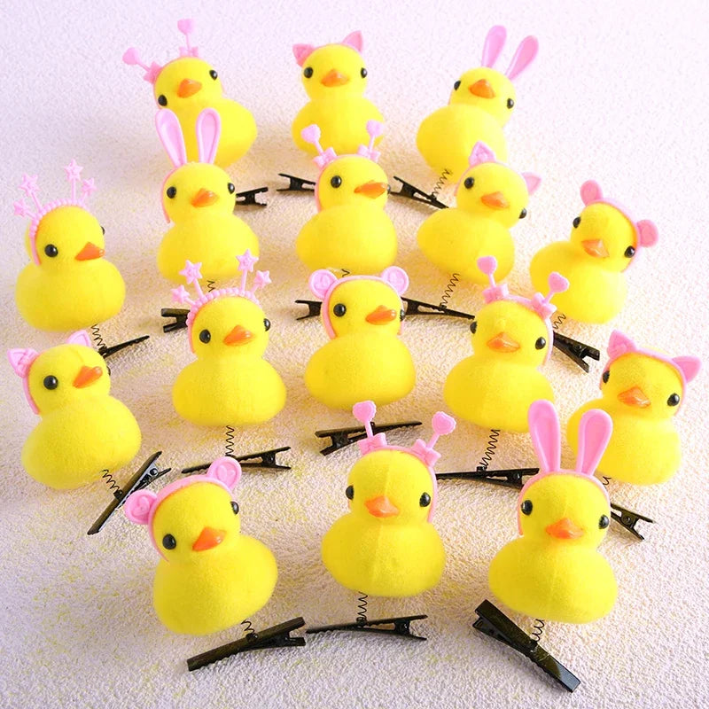 A collection of yellow duck plush hair clips with pink ears arranged on a white background.